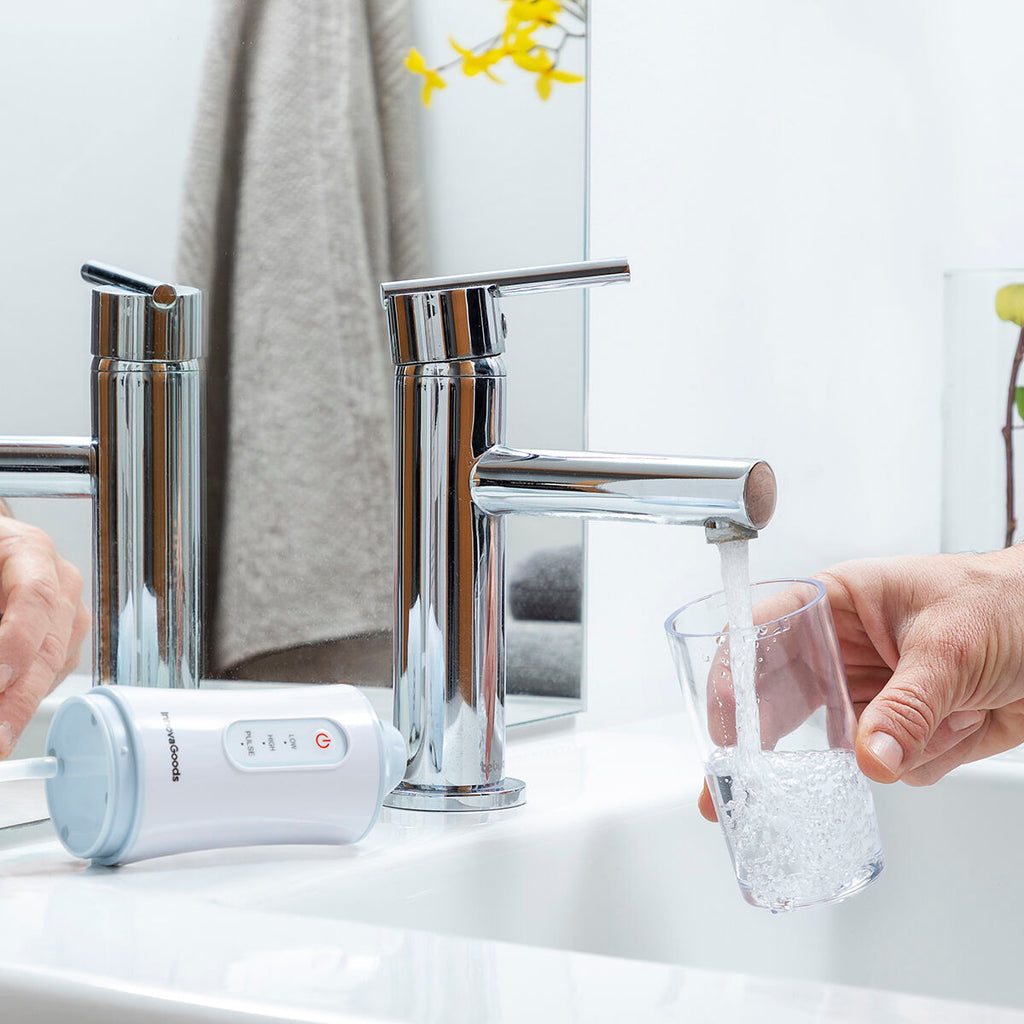 Portable blue and white cordless water flosser with interchangeable cleaning heads and USB cable. — view 6