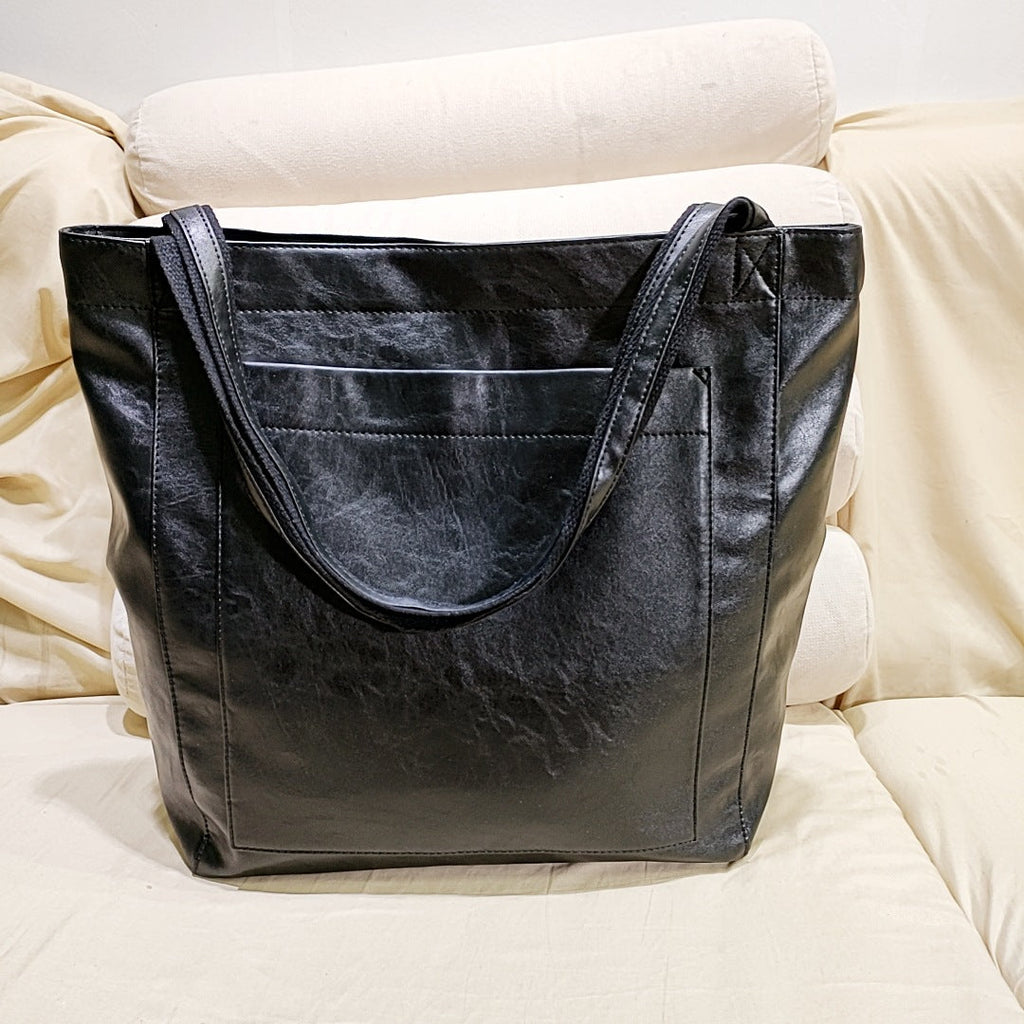 Black vintage genuine leather tote bag with reinforced shoulder straps for everyday use