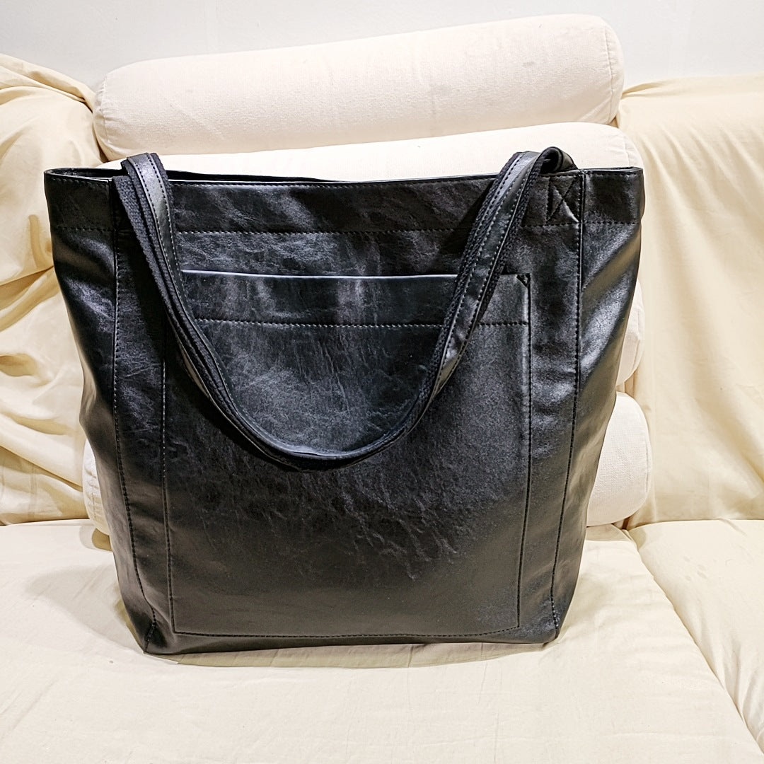 Black vintage genuine leather tote bag with reinforced shoulder straps for everyday use