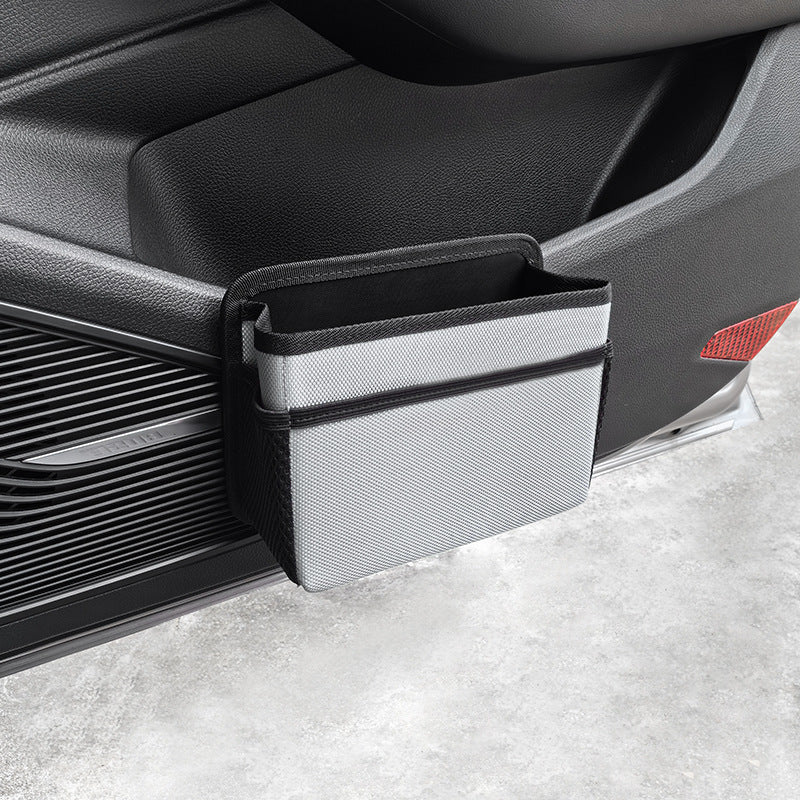Grey waterproof hanging car storage bag and back seat organizer attached to a car seat.