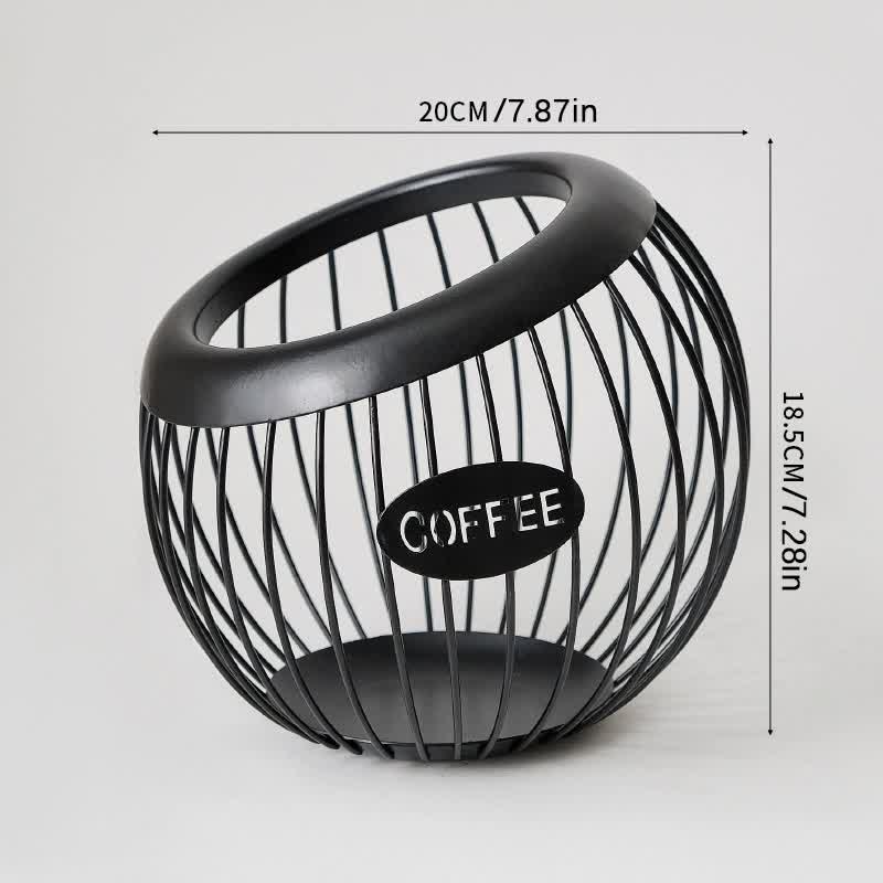 Black handcrafted vintage iron coffee capsule storage basket holding pods on a kitchen countertop