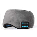 Grey wireless Bluetooth sleep mask with plush fabric cover and built in audio speakers