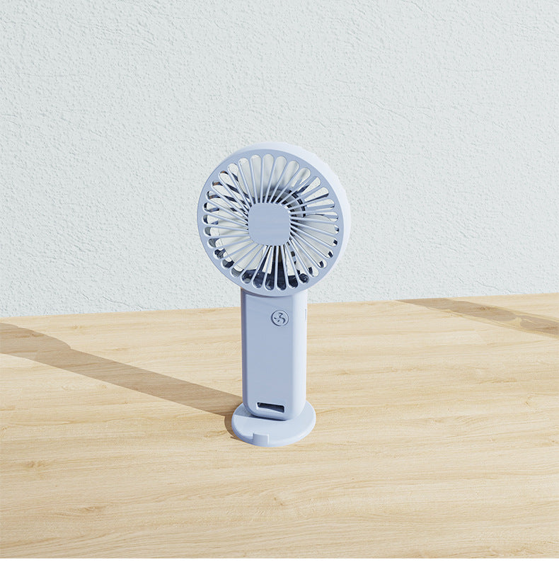 Blue portable USB mini handheld fan with desktop base and integrated phone stand.