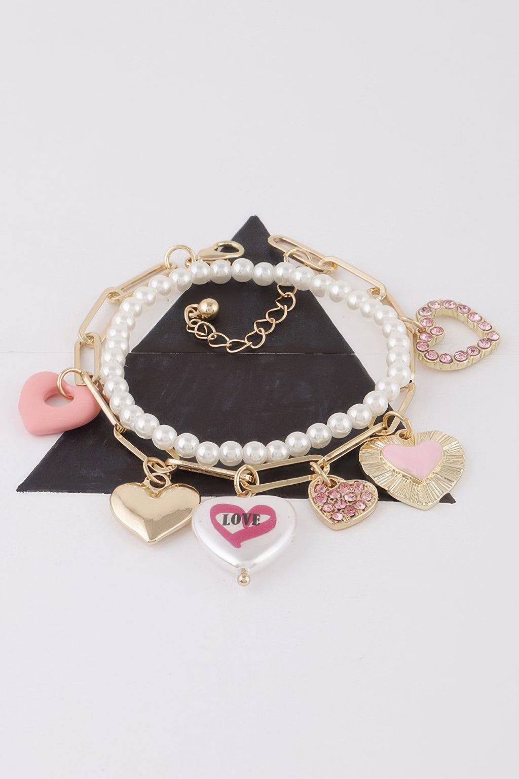 Women's heart charm bracelet in gold and silver cream, lightweight stackable romantic jewelry design.