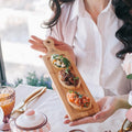 Rectangular natural bamboo serving tray with handle for appetizers and sliders on a table