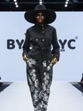 Women's black gabardine cropped jacket with high collar, wide waist belt, and large gold buttons