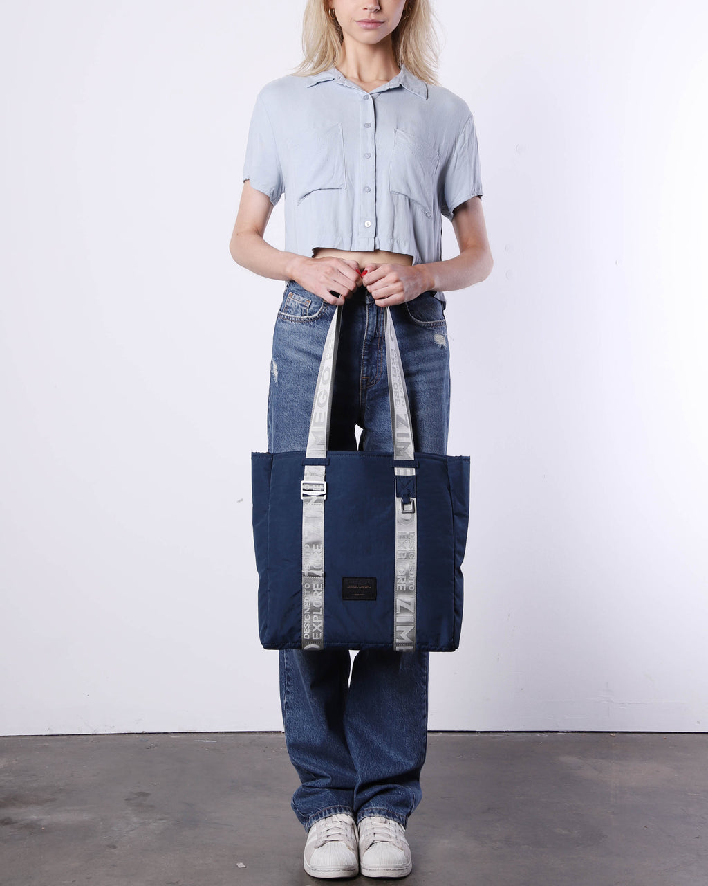 Navy blue nylon unisex laptop tote bag with adjustable metallic straps and padded tech sleeve