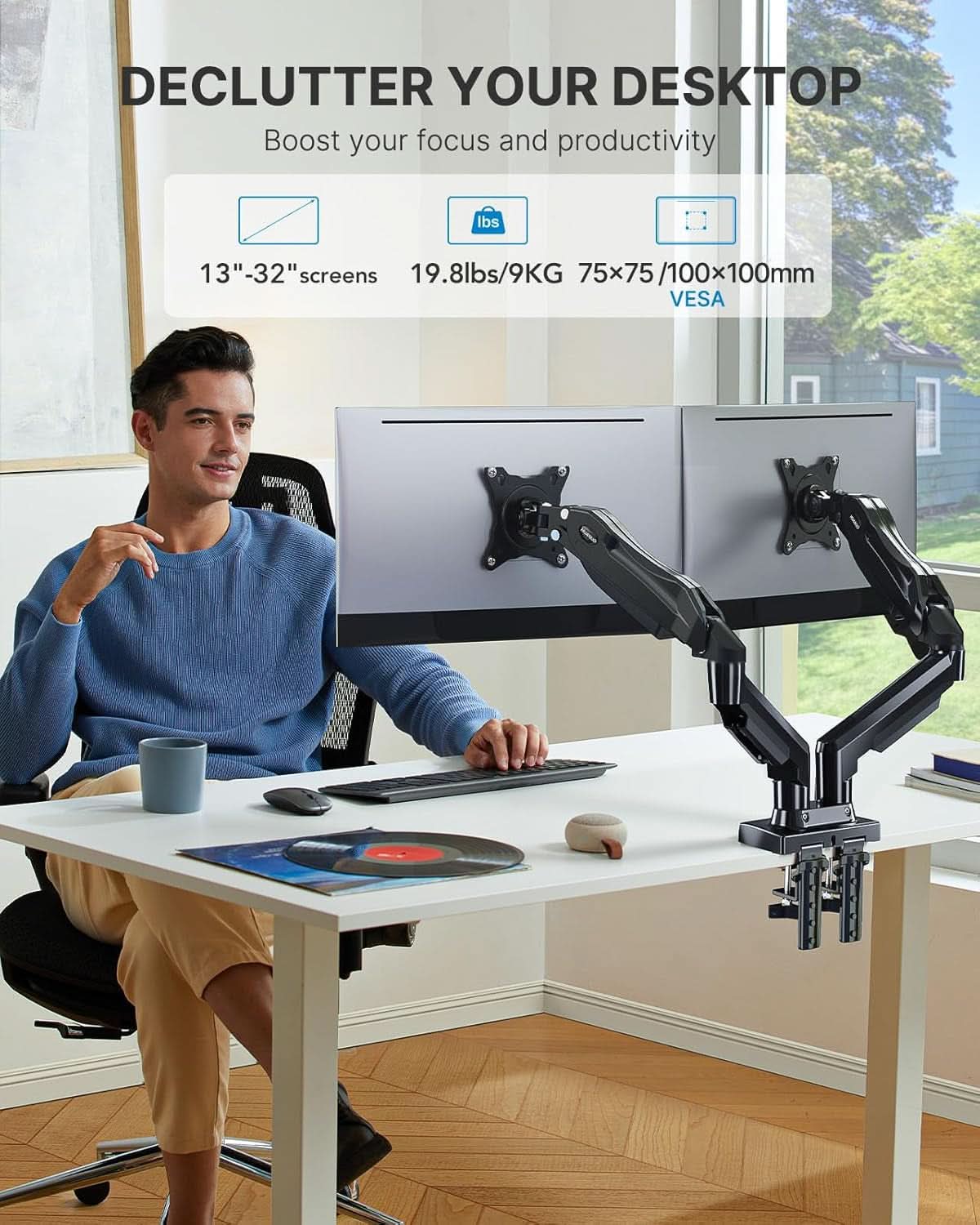 Adjustable dual monitor stand with gas spring arms attached to a wooden desk setup — view 2