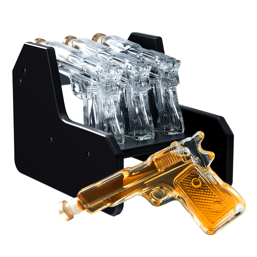 3-pistol whiskey decanter set made of glass resting on a rich mahogany wood display base