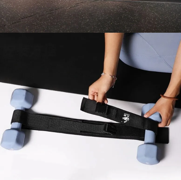 Black hip thrust belt with built-in padded cushion holding dumbbells for home glute bridge workout — view 4