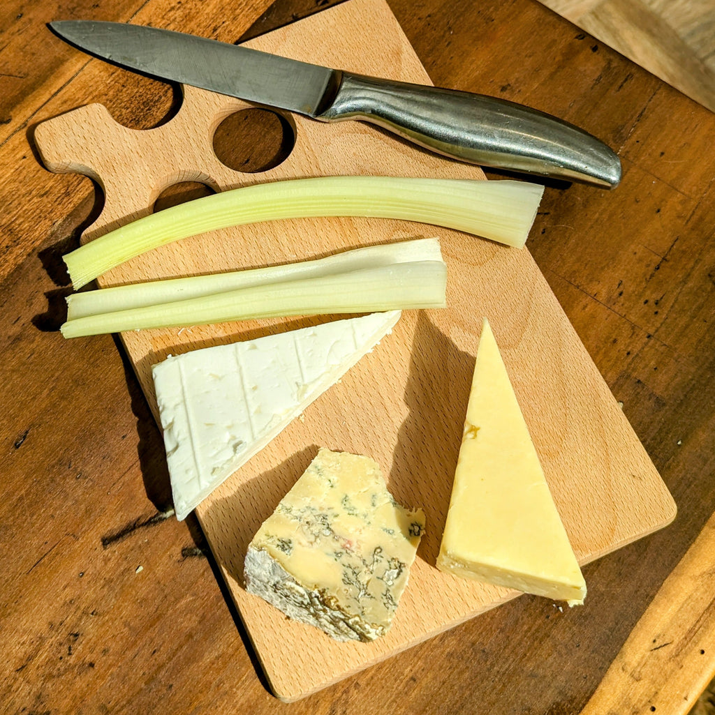 Beech wood cheese board with quirky cutout holes design, resting flat on a table surface — view 4