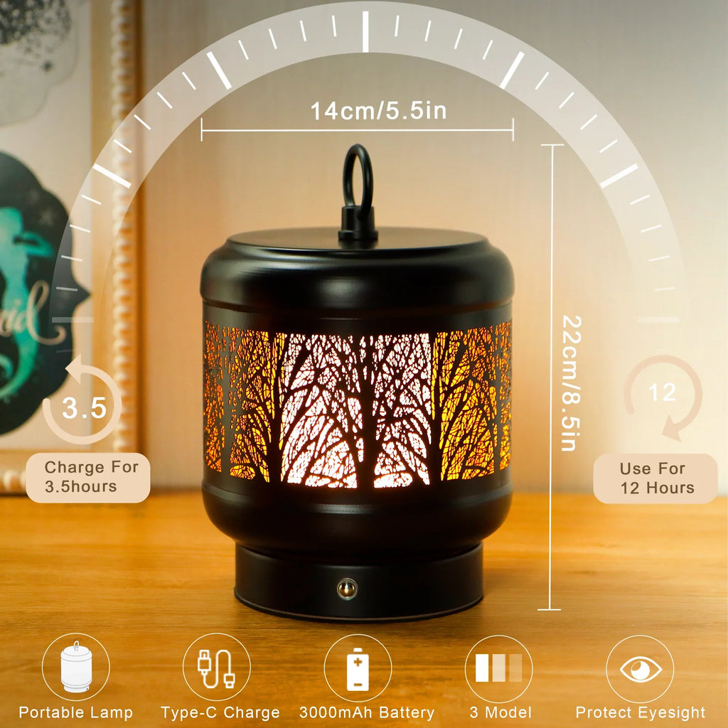 Rechargeable metal desk lamp with tree silhouette cutouts glowing in warm light on a table — view 2