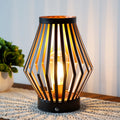 Set of two vintage bronze metal cage table lamps with warm glowing bulbs