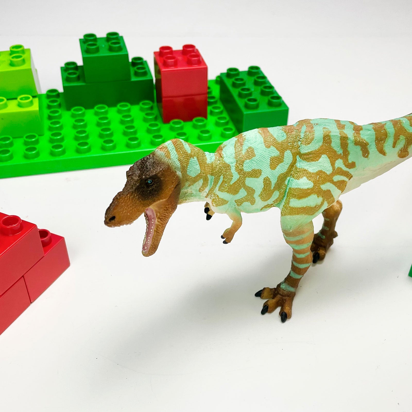 Albertosaurus toy dinosaur figure in brown and aqua camouflage pattern standing on white background — view 5