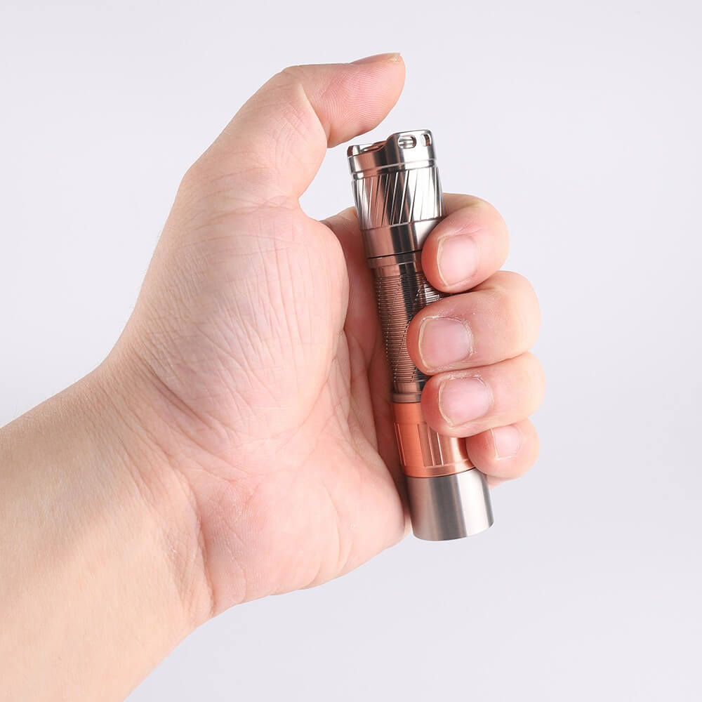 Compact titanium everyday carry flashlight with a metallic finish and tactical tail switch button — view 4