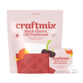 Black Cherry Old Fashioned cocktail mix packets next to a freshly prepared drink over ice