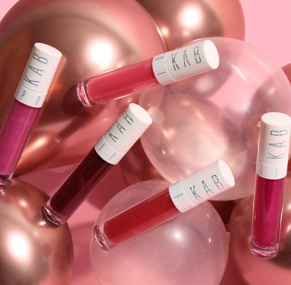 Hydrating tinted lip oil tube with large doe foot applicator and glossy pink sheen