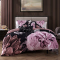 Black and pink floral reversible cotton comforter set with shams and decorative pillows on bed