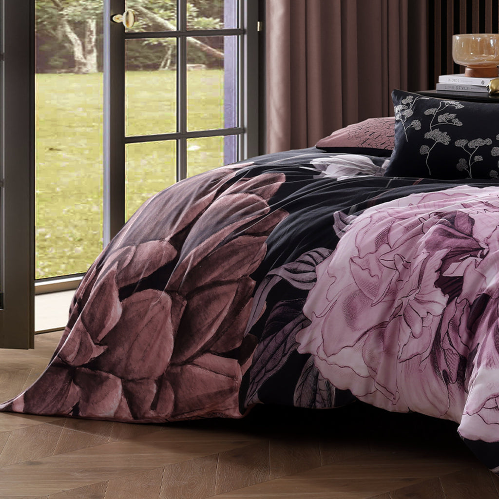 Black and pink floral reversible cotton comforter set with shams and decorative pillows on bed — view 4