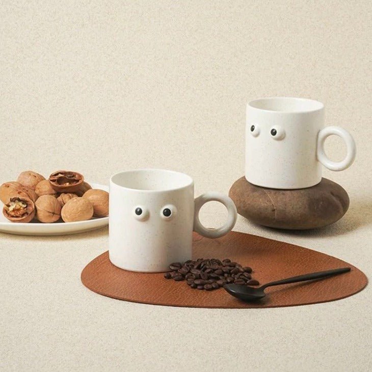 Handmade ceramic coffee mug featuring a funny big eyes cartoon design and a sturdy handle