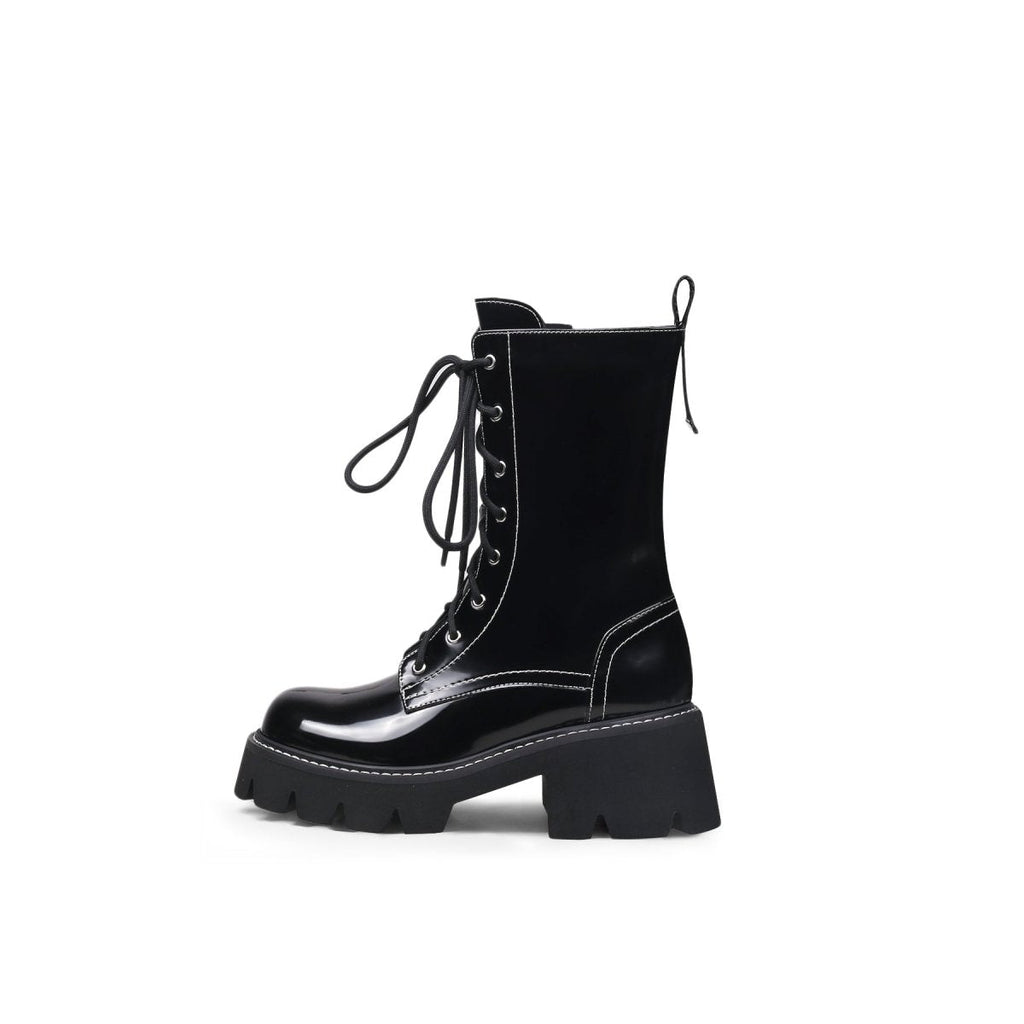 Black leather lace up combat boots with patent shine, block heel, and sharp stitching detail