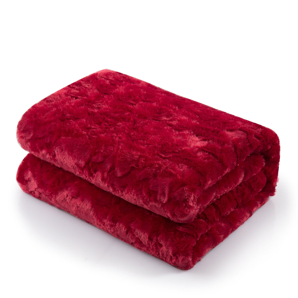 Red faux fur throw blanket with embossed hearts and fluffy white sherpa backing draped on couch — view 2