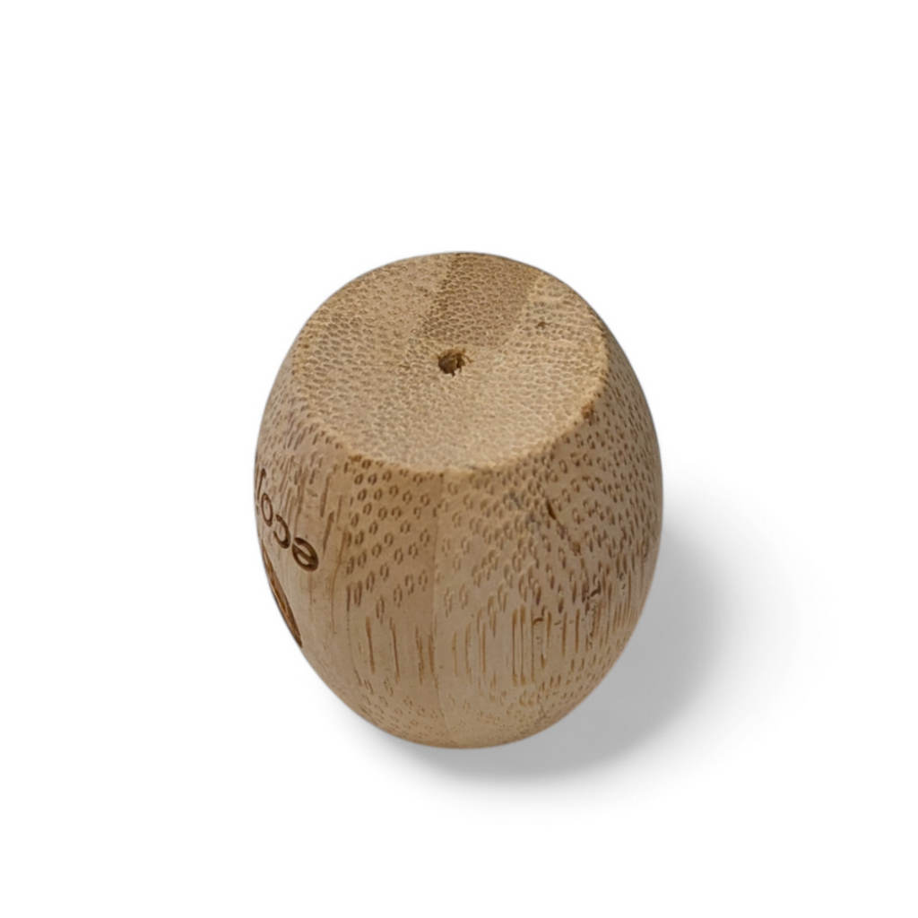 Unwaxed bamboo toothbrush stand on a bathroom counter holding a wooden adult toothbrush — view 3