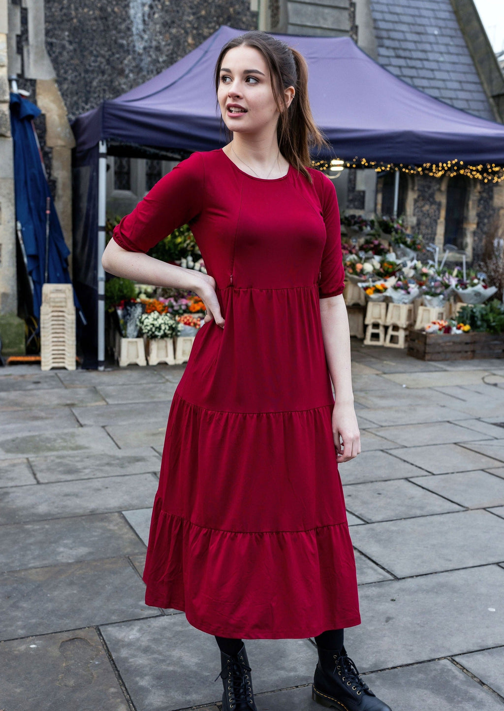 Burgundy cotton nursing midi dress featuring discreet zips, smock fit, and large pockets worn by model — view 5