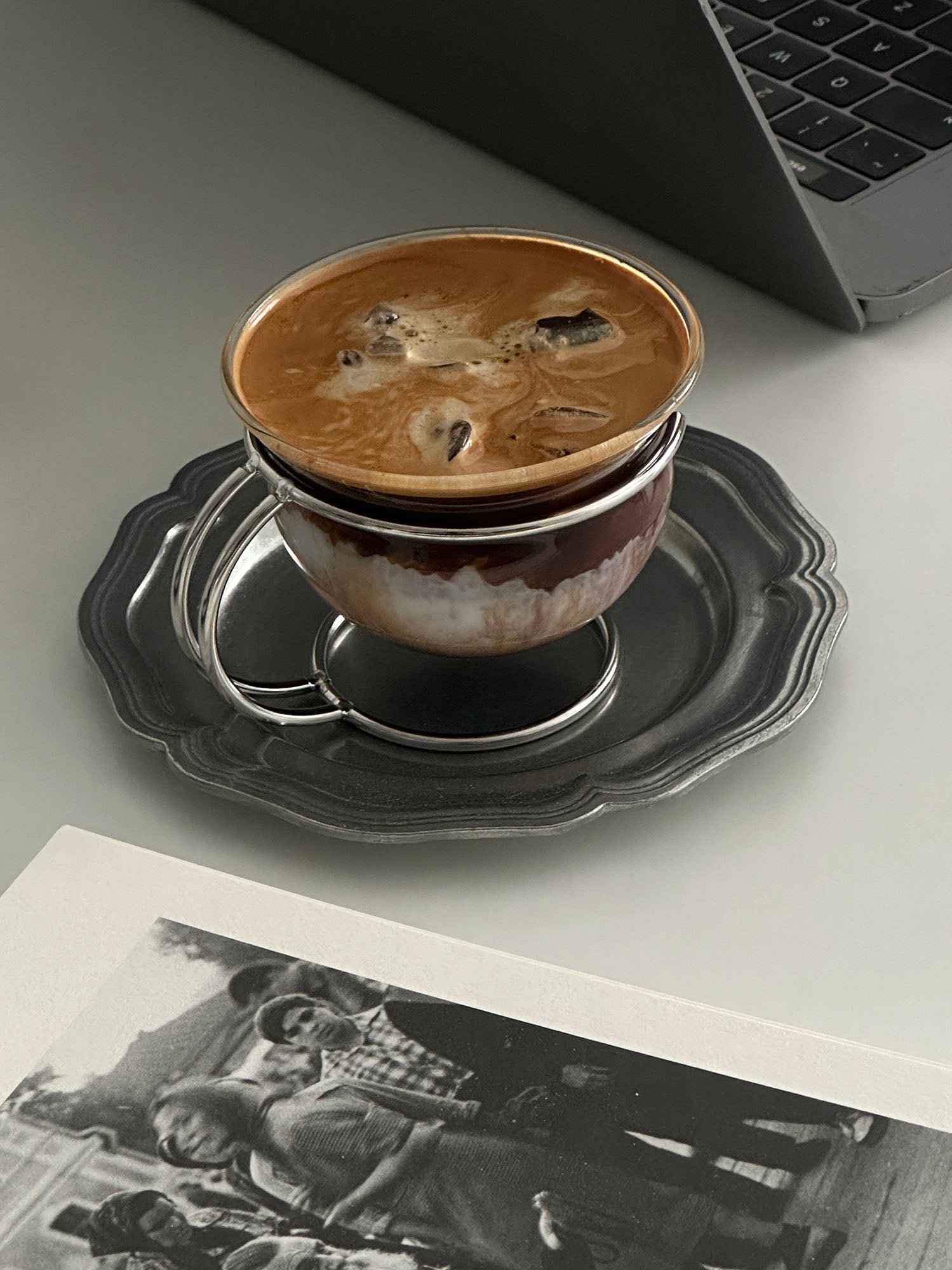 Clear vintage glass coffee cup resting in a sleek minimalist stainless steel wire holder — view 3