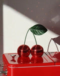 Two connected cherry disco balls covered in sparkling silver glass mosaic tiles