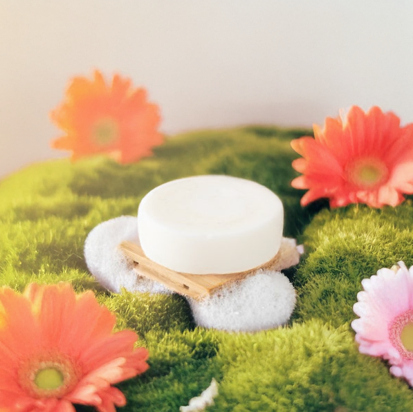 Round sulfate-free travel conditioner bar for hydrating hair care in zero-waste packaging