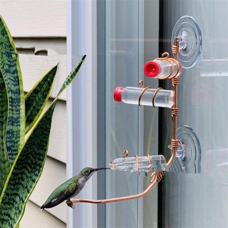 Handmade copper wire hummingbird feeder with clear nectar bottles and suction cups