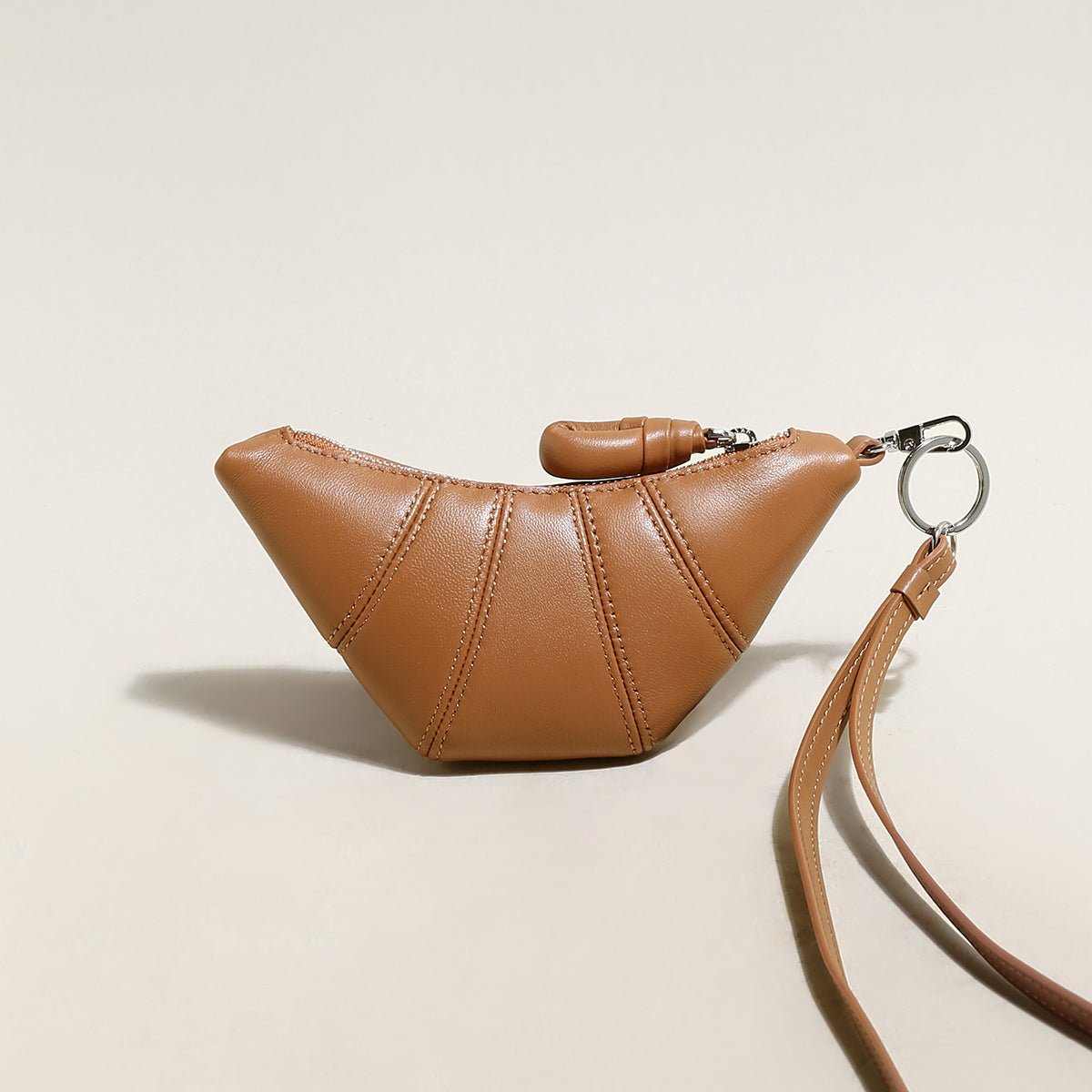 Soft vegan leather croissant mini pouch bag charm with wrist strap and zipper closure. — view 2