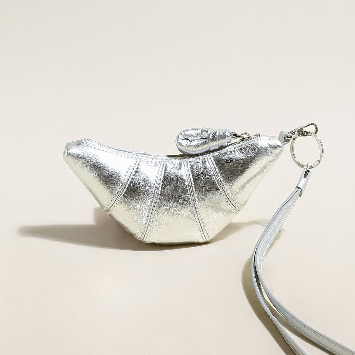 Soft vegan leather croissant mini pouch bag charm with wrist strap and zipper closure. — view 4