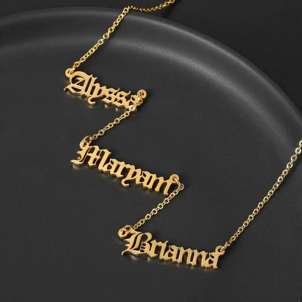 Personalized gold nameplate necklace featuring three custom name charms on an adjustable chain. — view 2