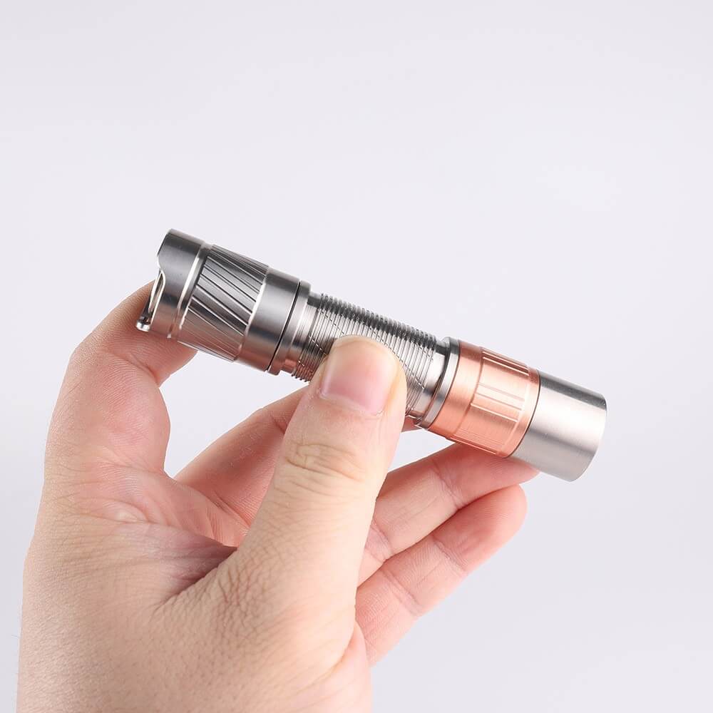 Compact titanium everyday carry flashlight with a metallic finish and tactical tail switch button — view 3