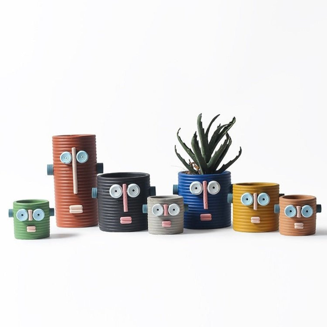Handmade ceramic dummy robot flower pot displaying a green succulent plant on a garden patio. — view 2