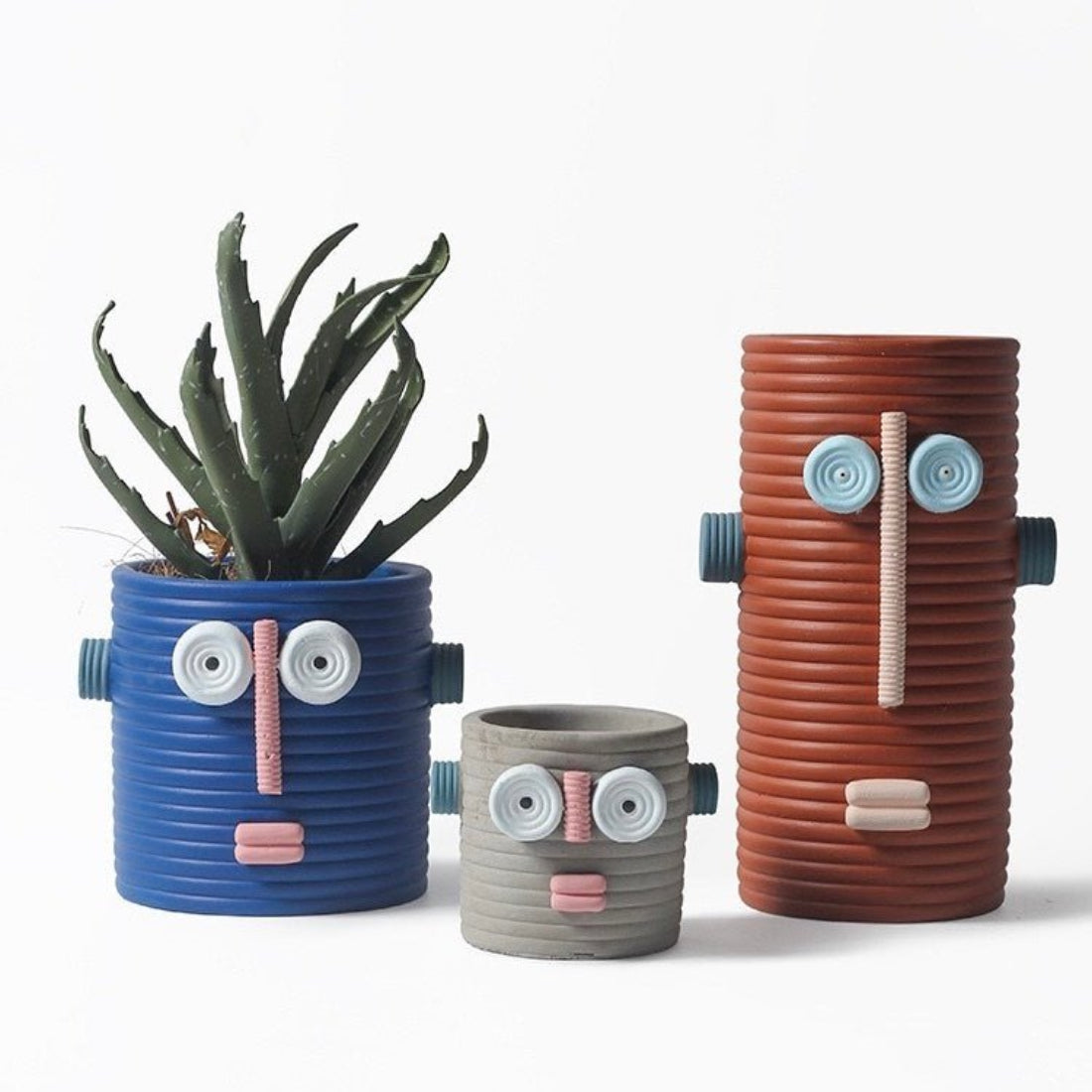 Handmade ceramic dummy robot flower pot displaying a green succulent plant on a garden patio. — view 5