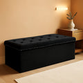 Black velvet storage ottoman bench with plush cushion, open to show hidden interior compartment space