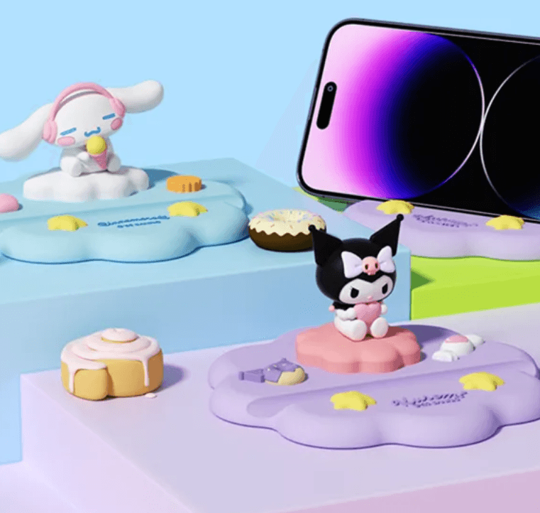 Cute Sanrio character desktop phone stand cradle featuring Kuromi and Cinnamoroll holding a smartphone securely