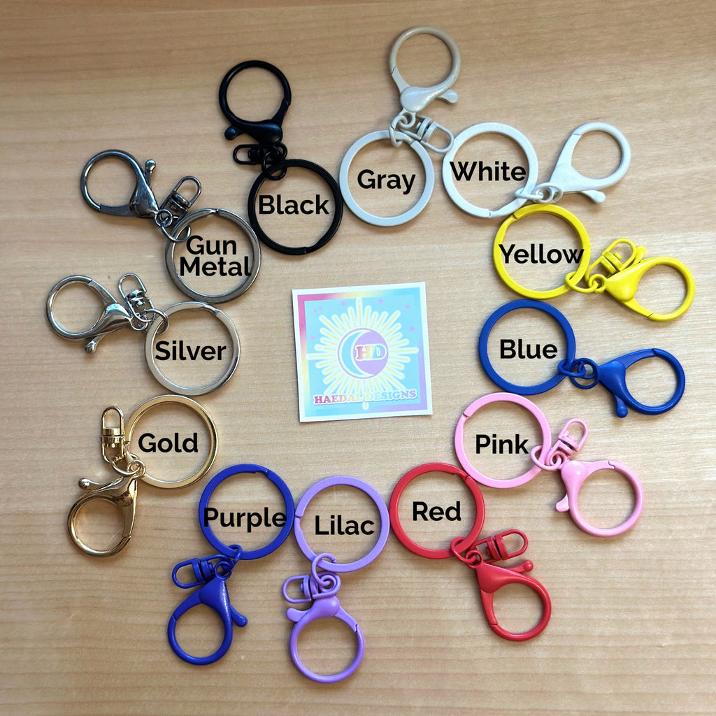 Custom Jung Kook logo charm keychain in vibrant PLA attached to a gold metal keyring — view 3