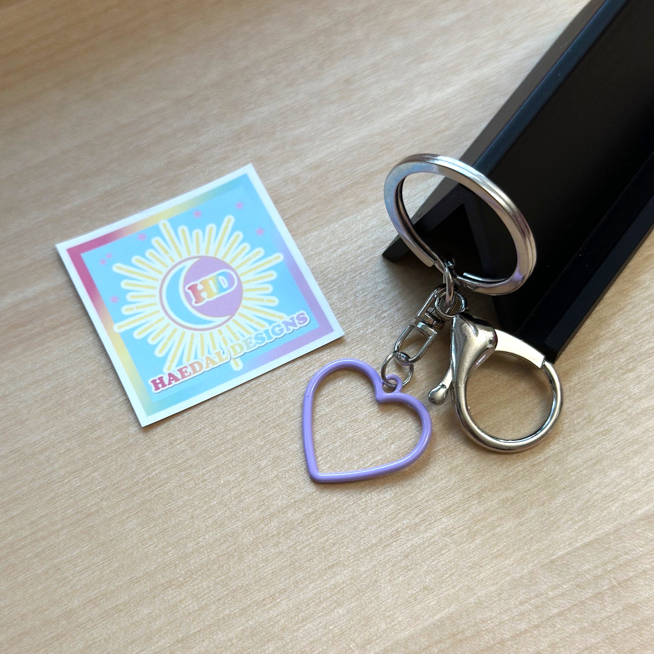 Custom Jung Kook logo charm keychain in vibrant PLA attached to a gold metal keyring — view 6