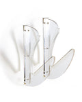 Clear acrylic horizontal surfboard wall display rack with cushioned bumpers supporting a surfboard.