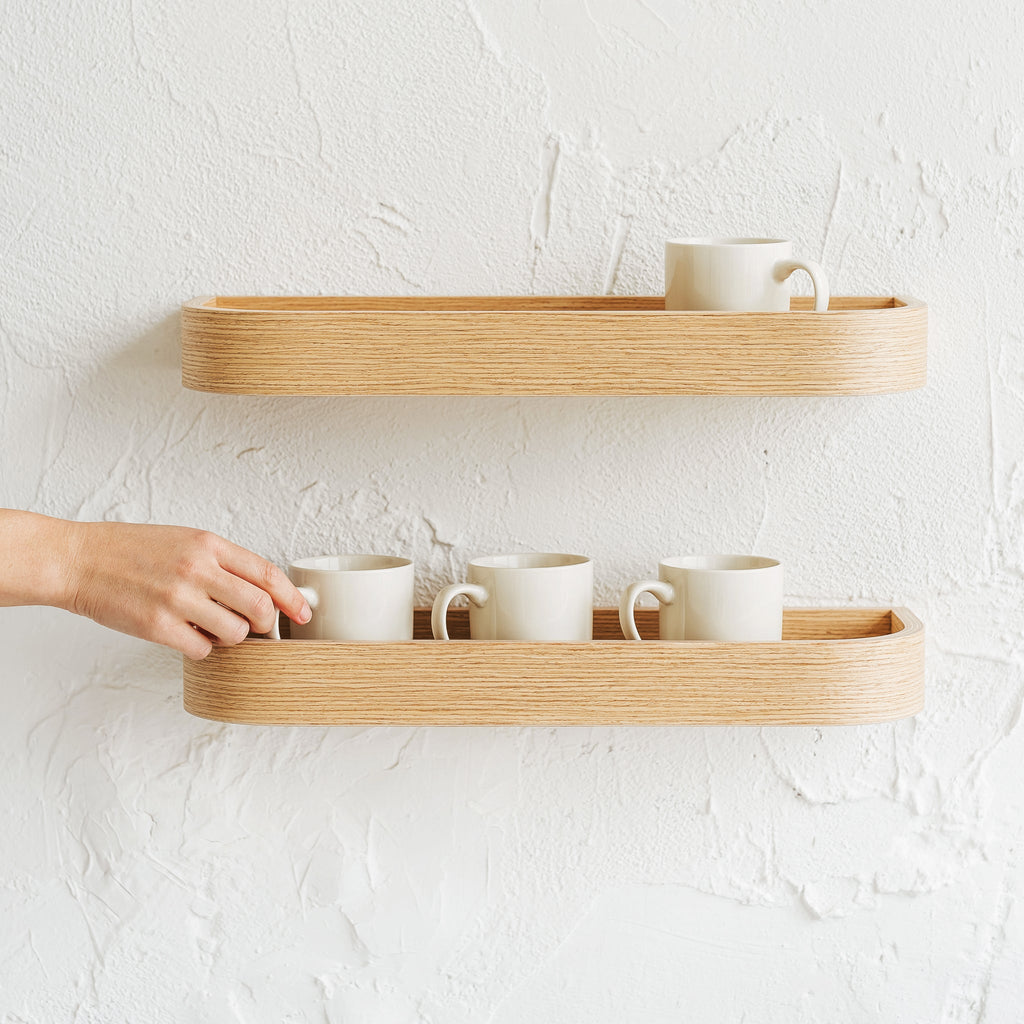 Natural oak wood floating wall shelf holding small decorative plants and picture frames in modern home — view 4