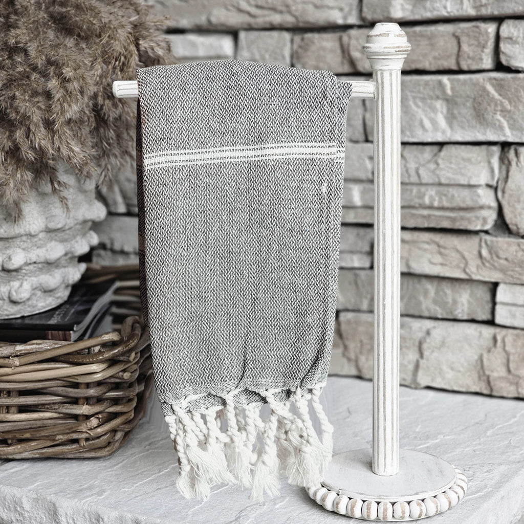 Oversized Turkish hand towel in premium cotton with natural bamboo tassels folded on a flat surface