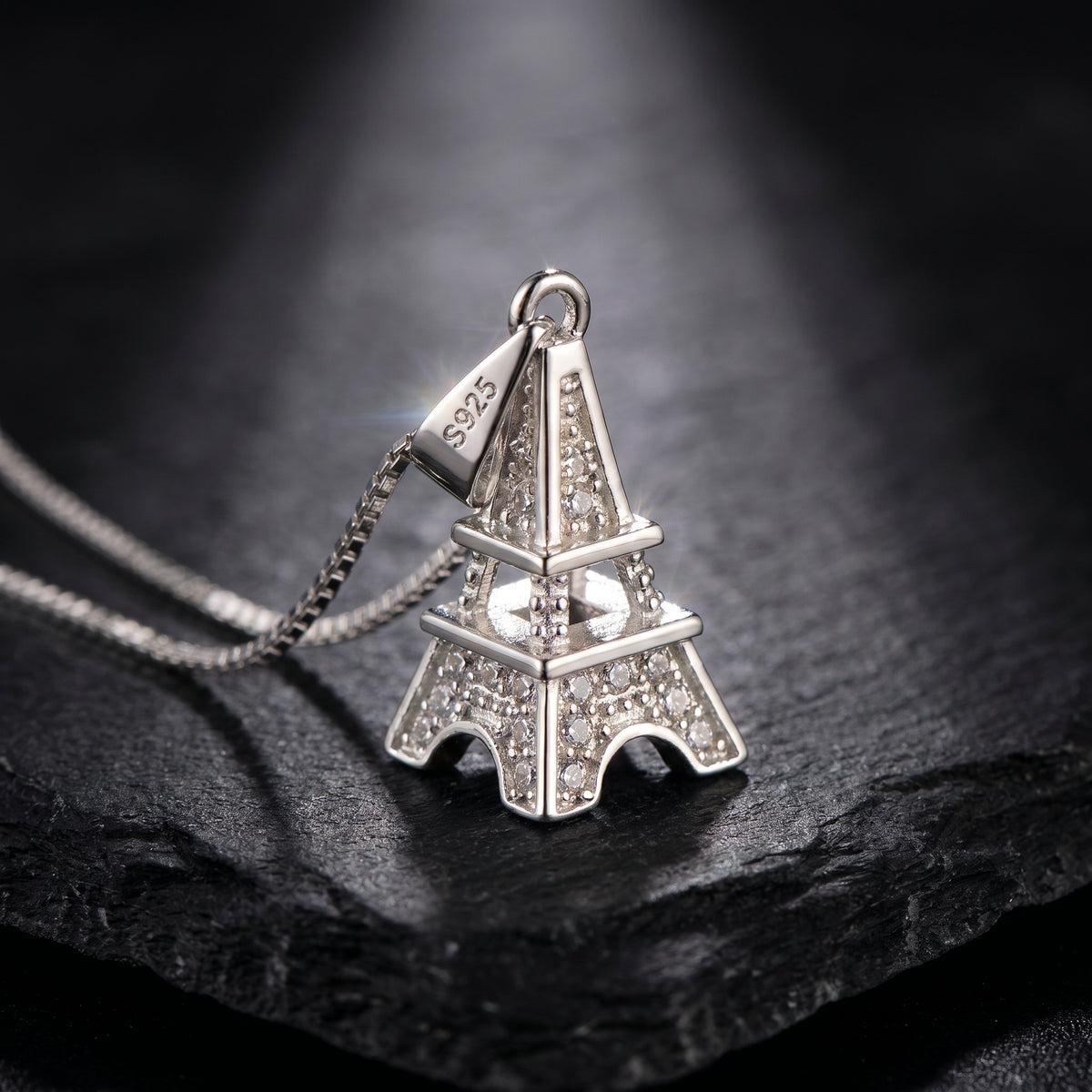 Luxury 925 Sterling Silver Eiffel Tower Pendant Necklace featuring pavé zirconia crystals, visible S925 hallmark, and elegant box chain showcased on a premium black stone background.
