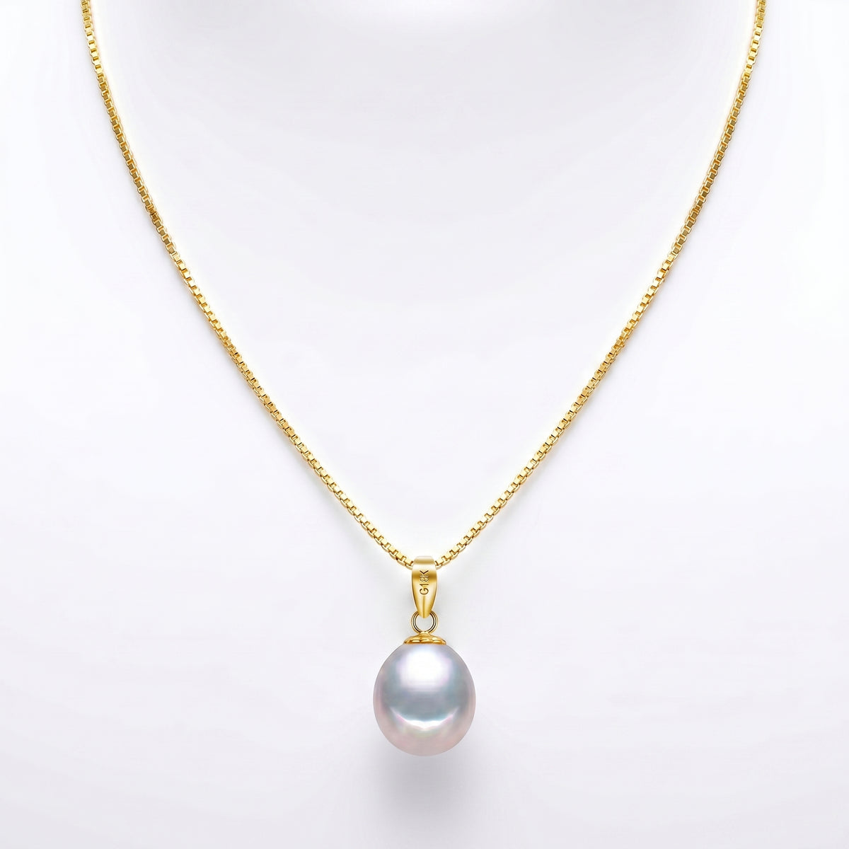 Freshwater pearl pendant necklace displayed on luxury stone pedestal with soft natural light.
