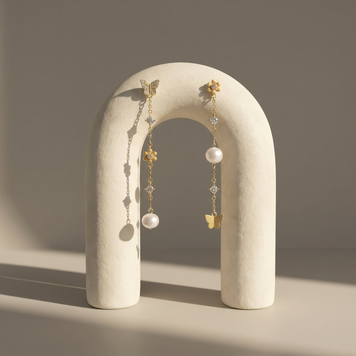 Woman wearing 18K gold plated sterling silver butterfly pearl drop earrings with cubic zirconia and freshwater pearls