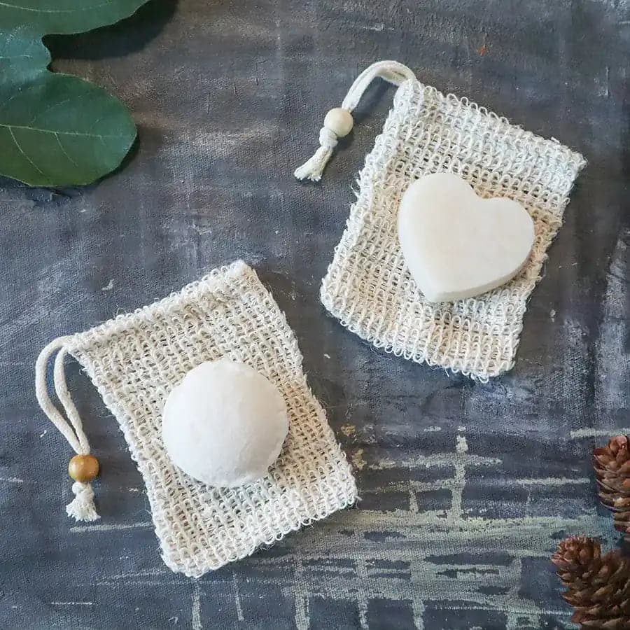 Round zero waste hydrating solid conditioner bar infused with lavender and shea butter on soap dish — view 3