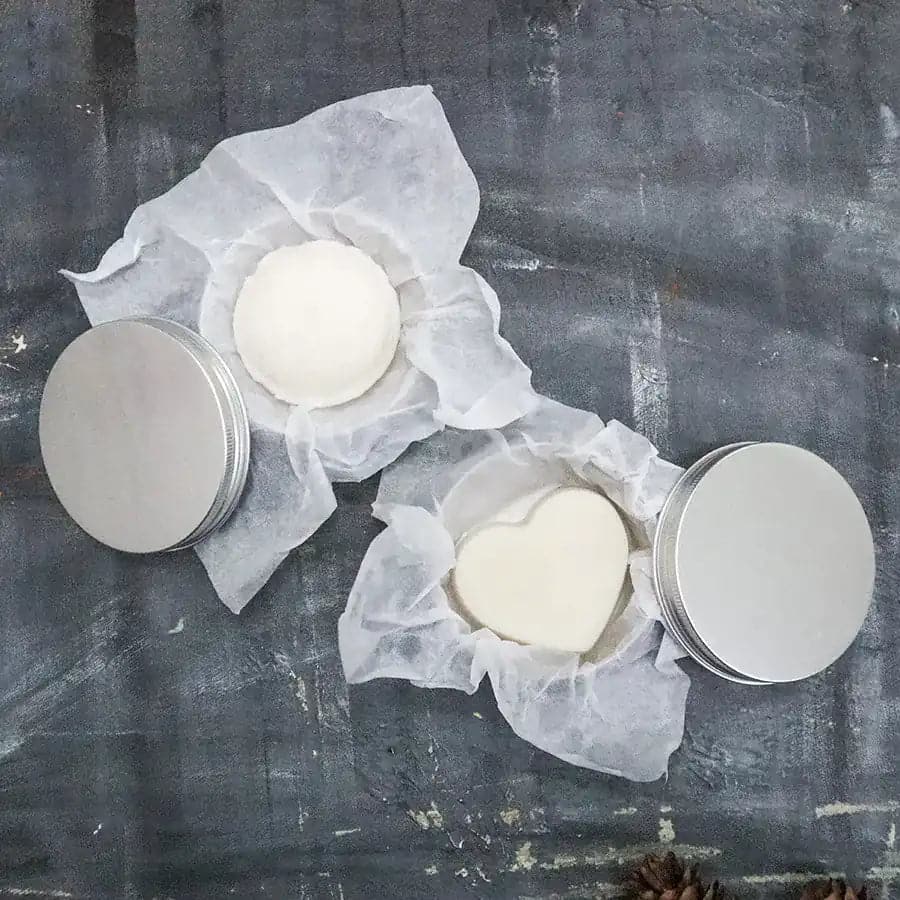 Round zero waste hydrating solid conditioner bar infused with lavender and shea butter on soap dish — view 5